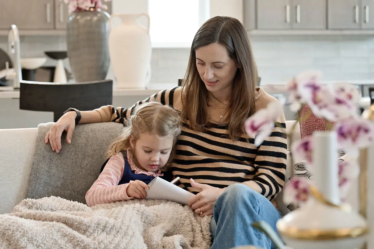 woman and child sitting and reading on the couch