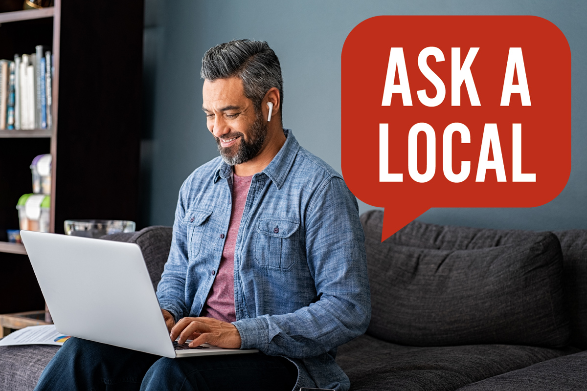 Man on laptop with ear buds in doing research