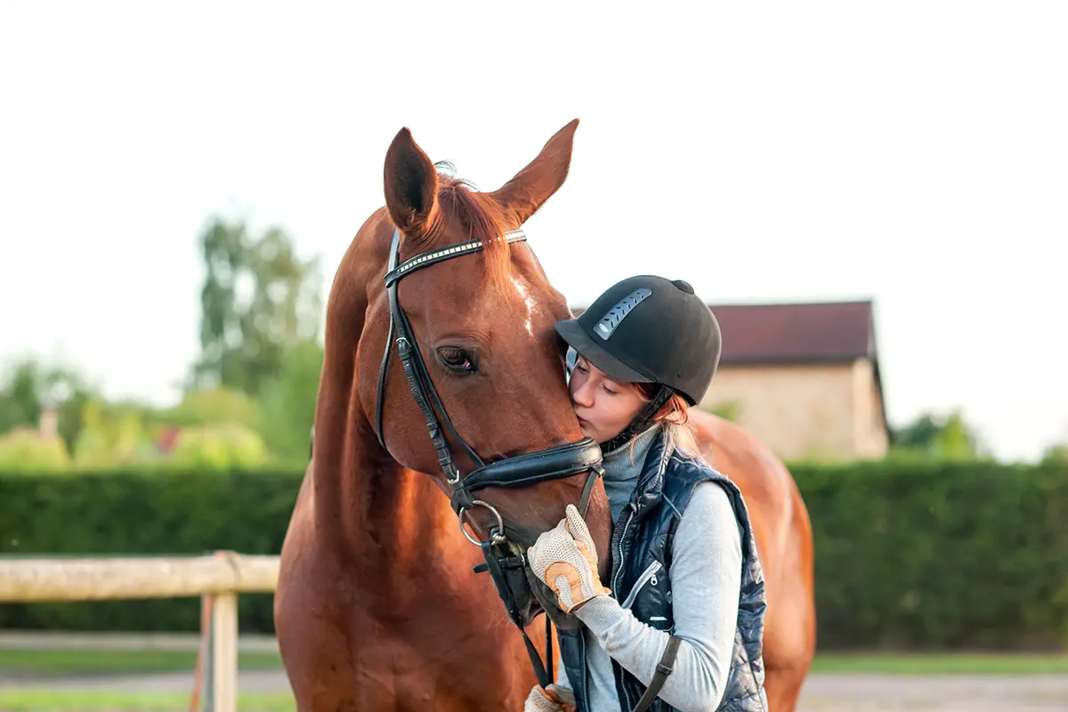 Teen kissing horse's nose