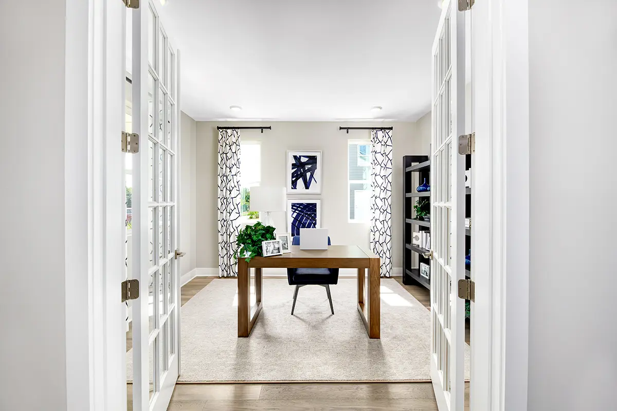 A private study with double doors and a desk in the middle