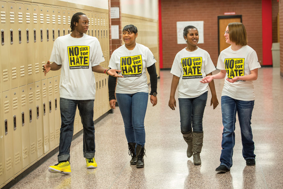 Four anti-defamation league students walking down school hallway