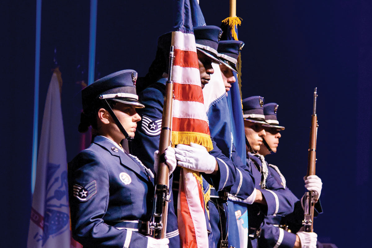 Police color guard standing on stage holding American flag