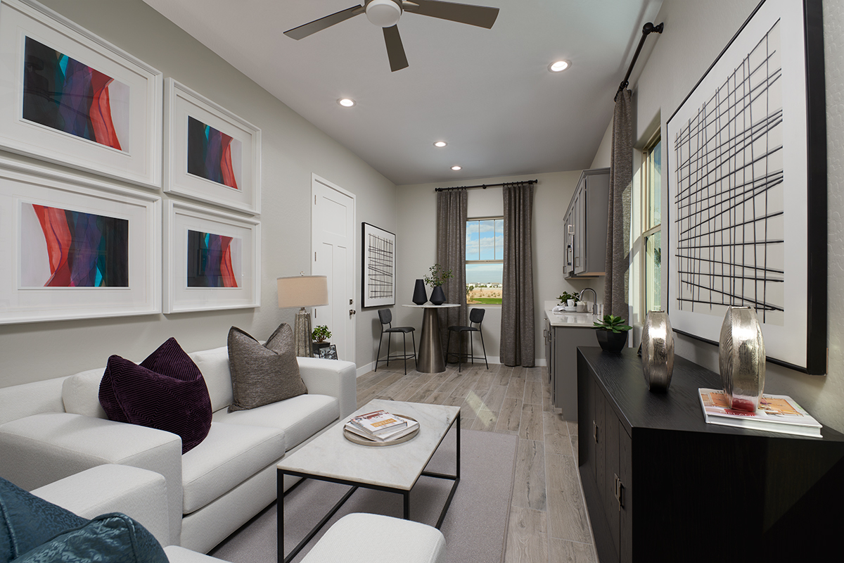 Guest living space with sink space, grey walls, colorful artwork