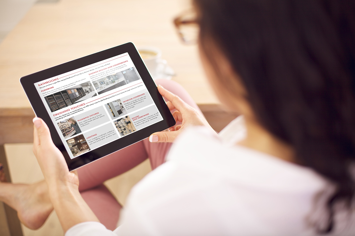 Woman with glasses sitting down holding tablet with both hands looking at Home Gallery content