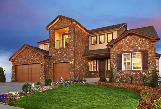 Two-story stone home with second floor porch and three-car garage