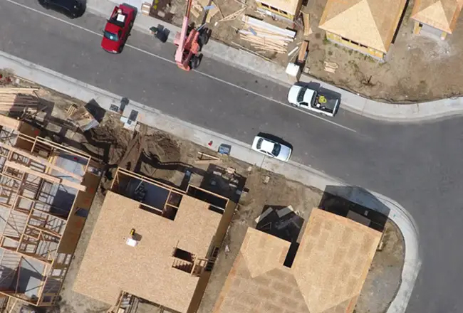 Overhead view of construction site with cars parked out front