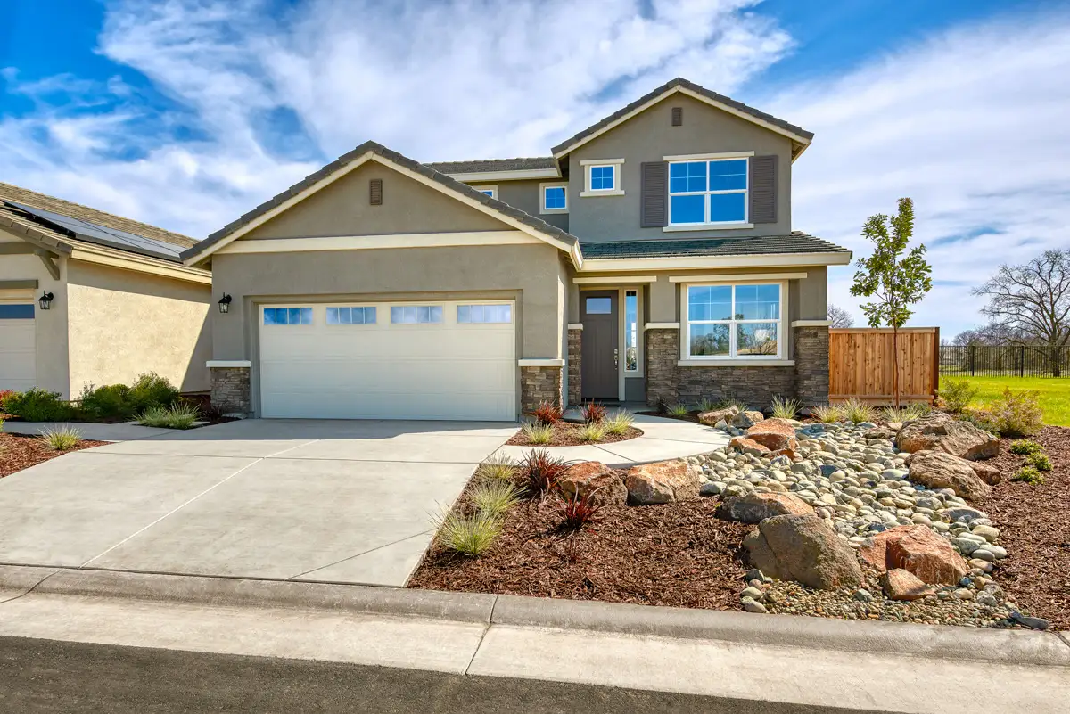 Two-story home with stone accents and wooden fence