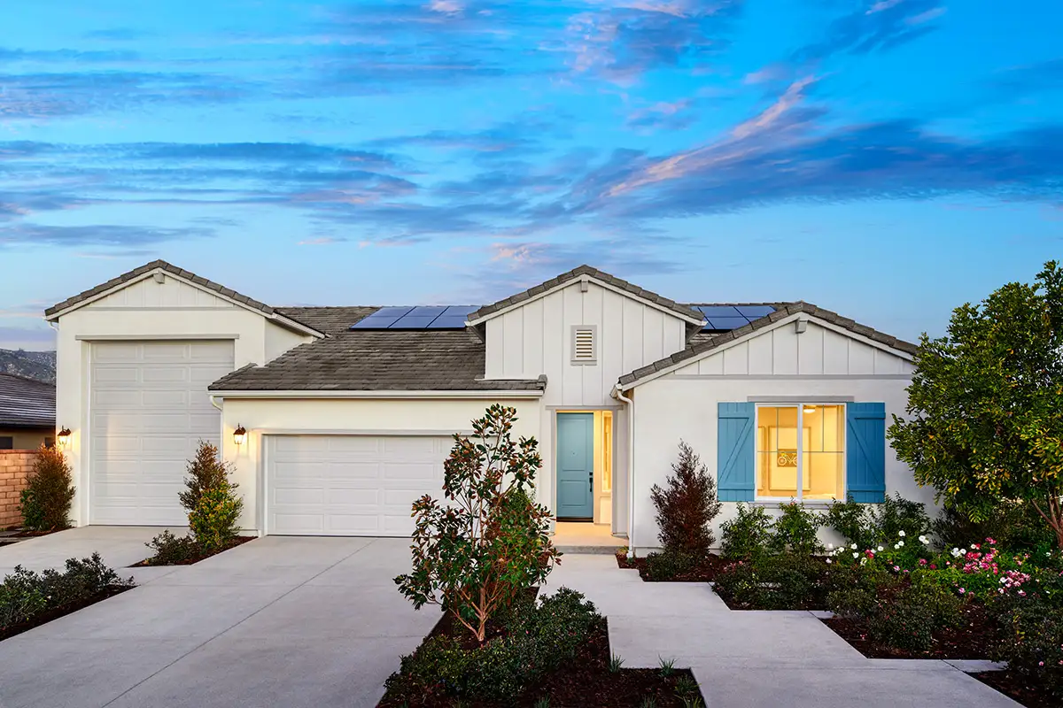 White home with two-car garage plus ultragarage and blue front door and shutters