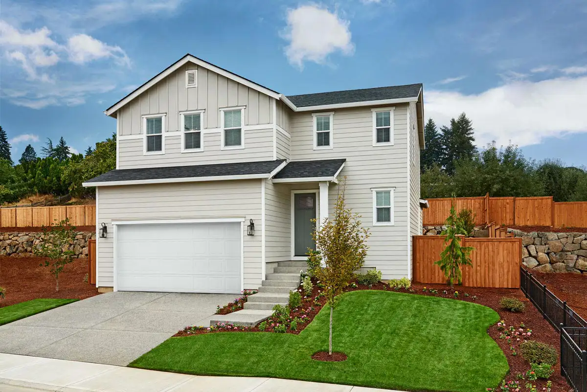 Two-story home with two-car garage and stairs leading up to front door