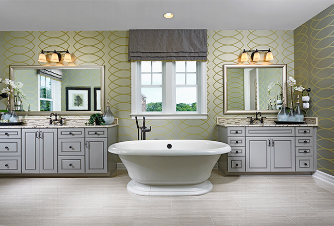 Large bathroom with two vanities separated by a soaking tub, with patterned wallpaper on the walls