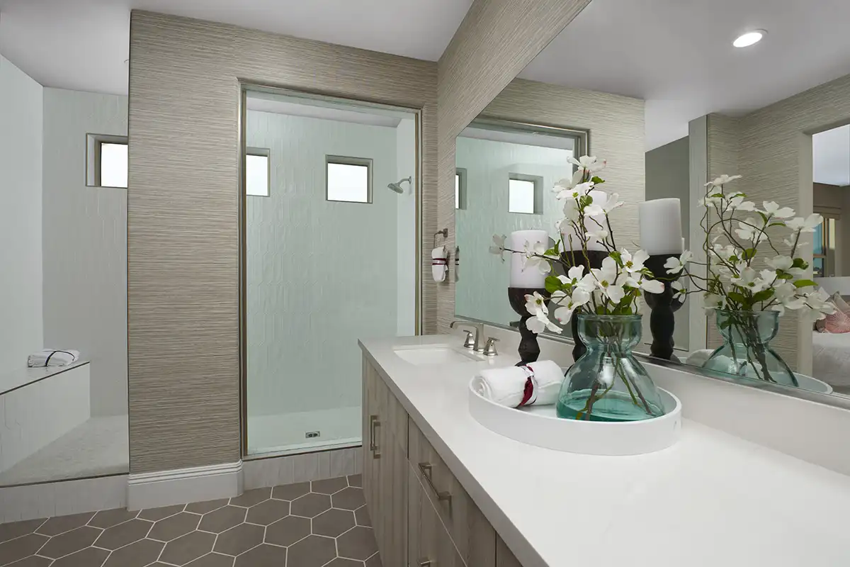 Bathroom vanity with two sinks and large shower stall with three small windows and seat