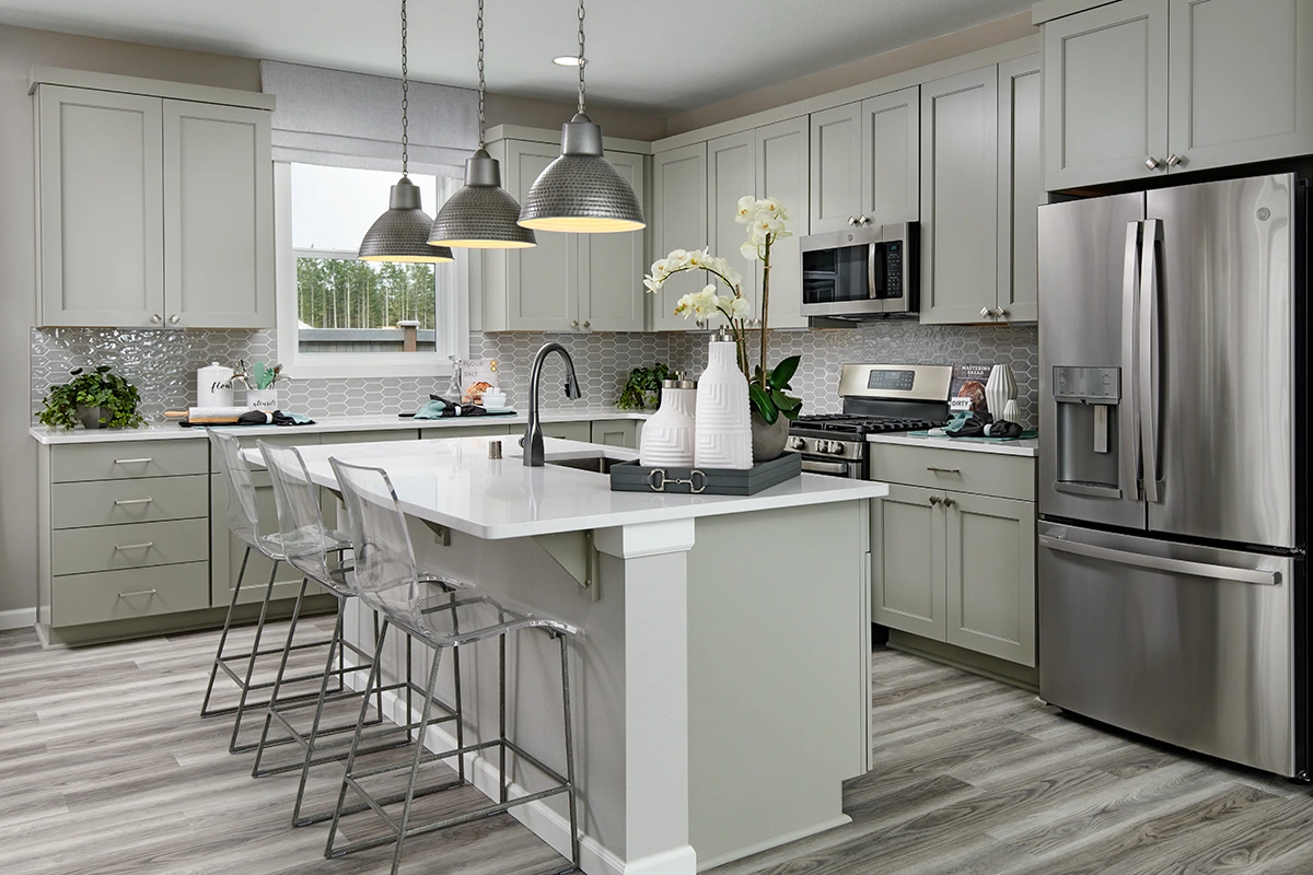Kitchen with island, gas stove, picket backsplash, and window facing backyard