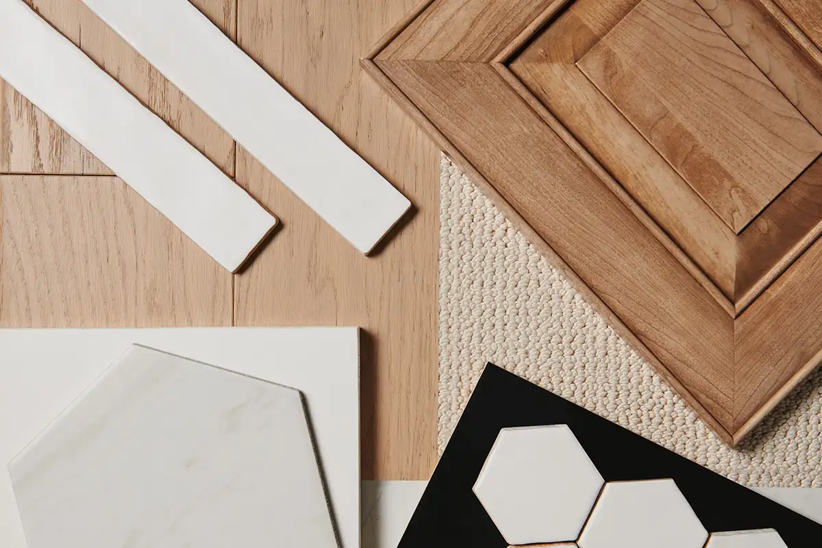 Bonus white color studio samples laid on a table, including tiles, flooring, and a cabinet sample