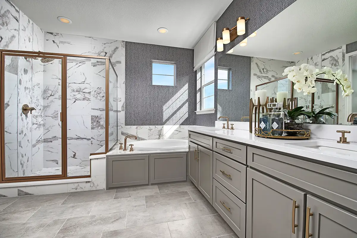 Bathroom design: Bathroom with gold finishes, marble-look wall tile and grey wallpaper, gray cabinets