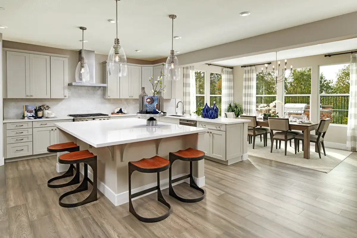 Kitchen design: Open kitchen layout with white cabinets/countertops, black and orange chairs and light brown flooring