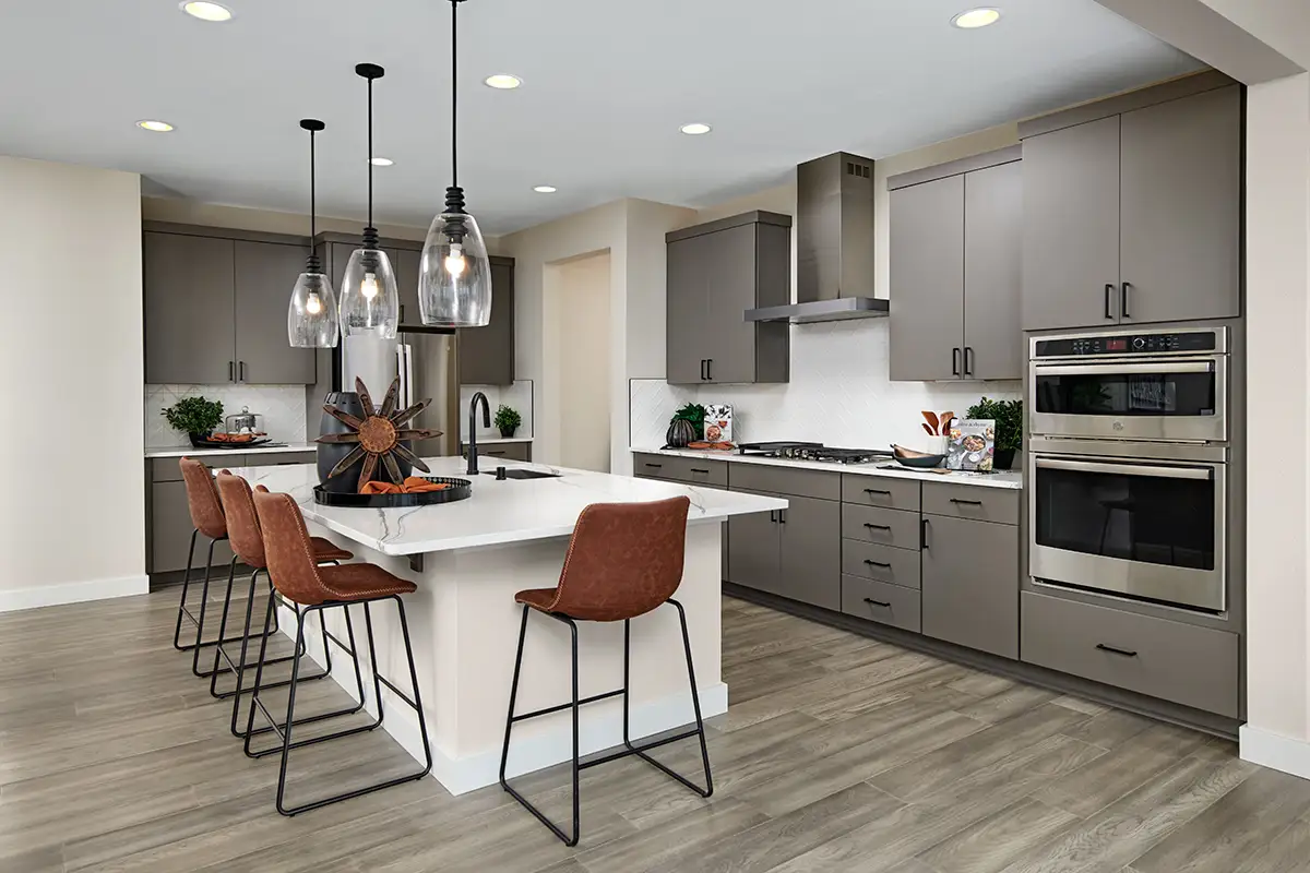 Kitchen with gray cabinets and black hardware, with large white island