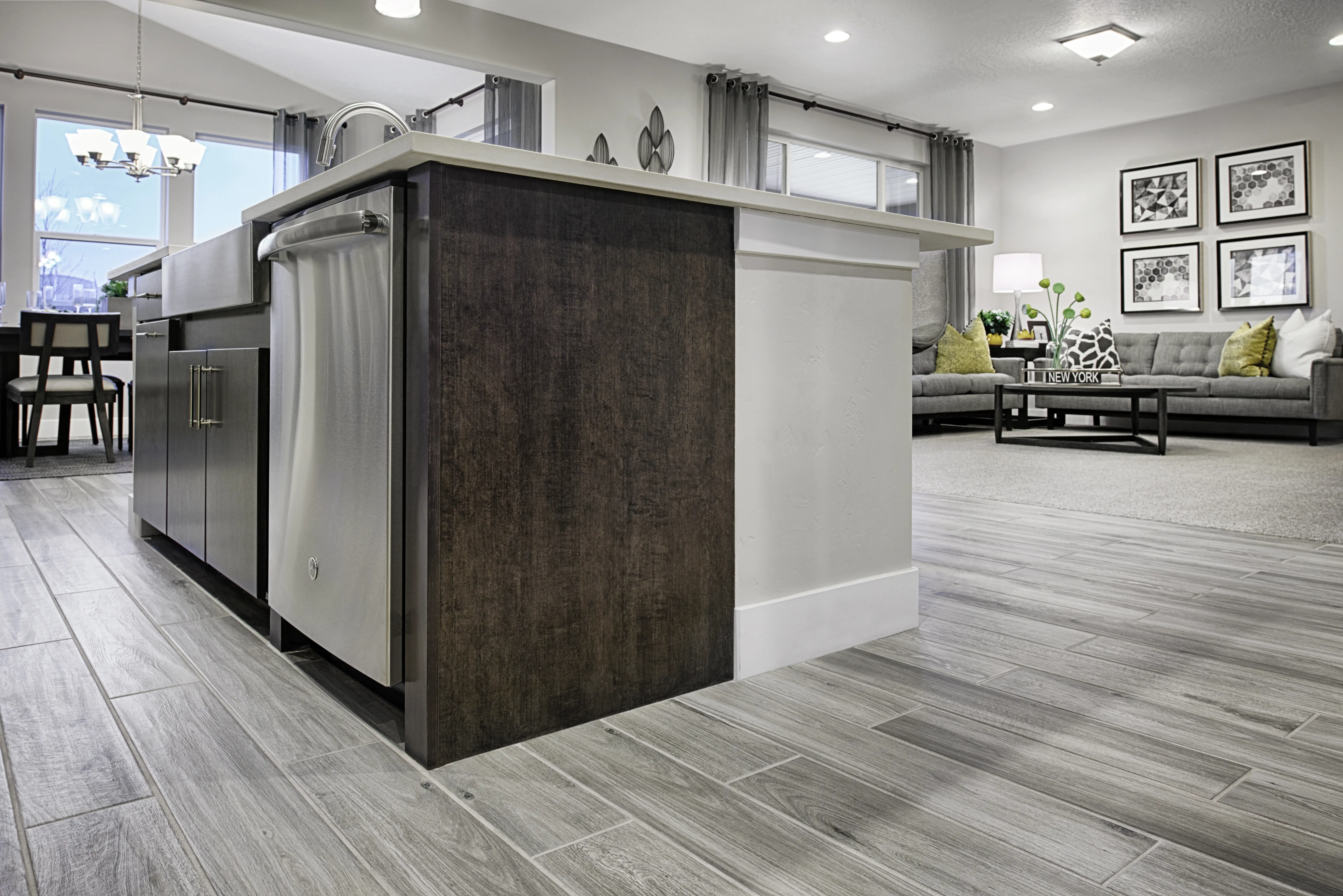 Dark wood kitchen island with dishwasher and living room in the background