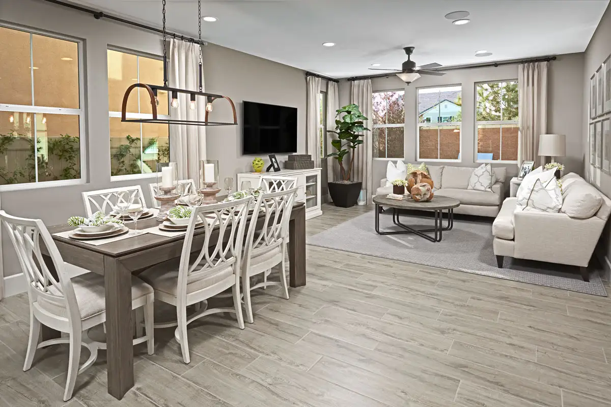 Dining table and living room area with light wood floors, chandelier, ceiling fan with light, and recessed lighting