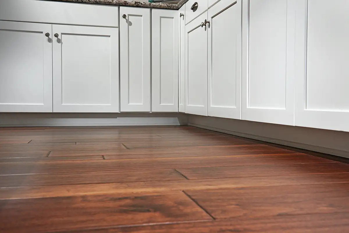 Wood flooring with white cabinets above