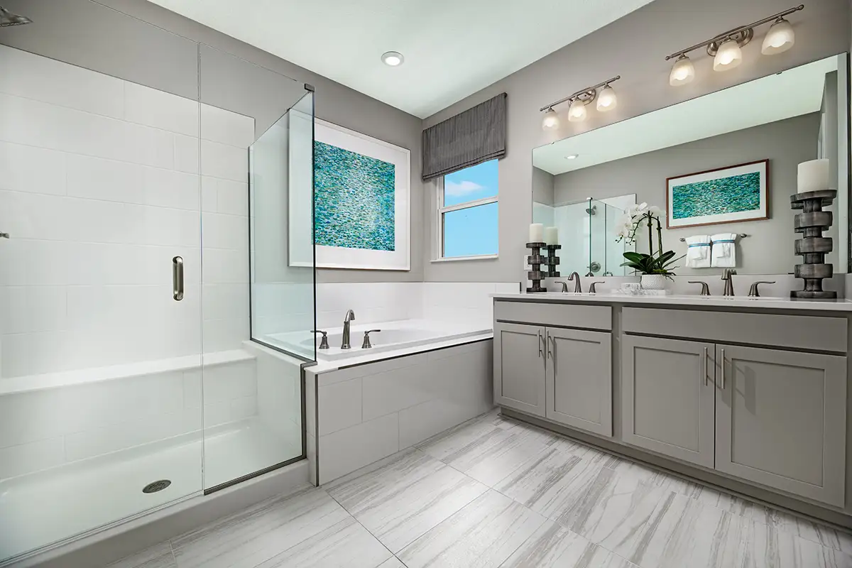 Large bathroom with double sink vanity, bathtub next to window, and shower stall