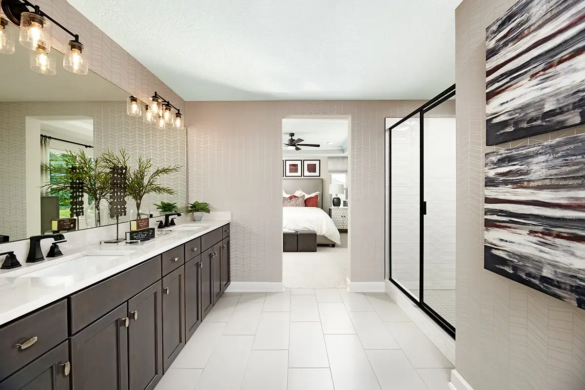 Large double sink vanity with white countertop and dark cabinets, and large shower stall