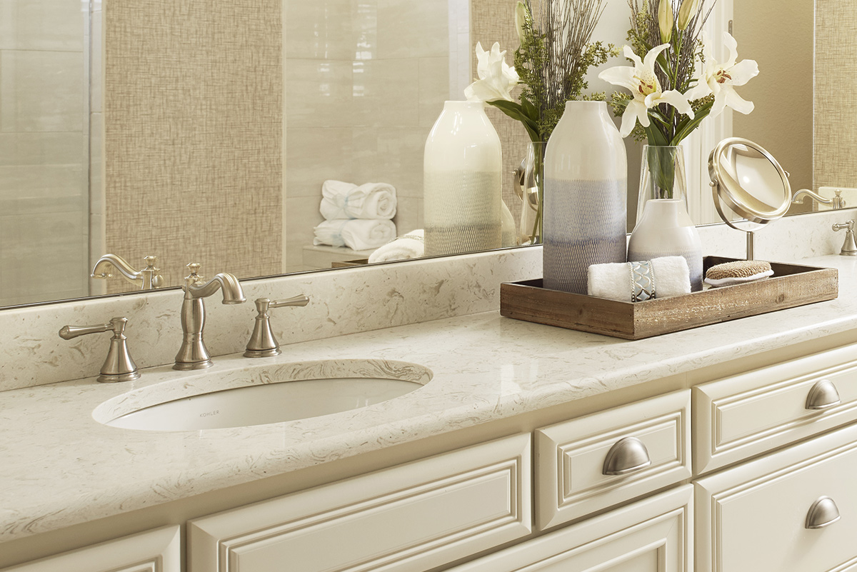 Vanity with two sinks and silver hardware below large mirror showing reflection of shower stall